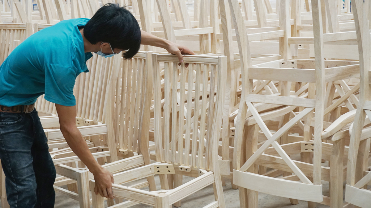 Ground level of green leaf on pyramid of pellets placed near stack of chopped firewood of various types and biomass briquettes in daylight