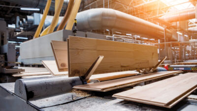 Production line of the wooden floor factory. CNC automatic woodworking machine. Industrial background