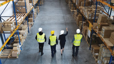 Top rear view of a group of workers with manager working indoors in warehouse, coronavirus concept.