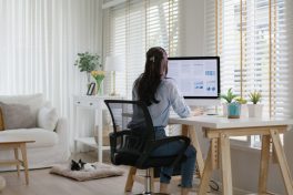 Smart Gen Z tech talent workforce typing SEO sale report on desktop PC happy work easy relax at home office. Remote WFH reskill upskill job MBA study of young people asia woman examine big data graph.