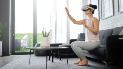 VR, metaverse and futuristic with a woman in the living room of her home using a headset to access a 3d game. Technology, virtual reality and gaming with a female gamer using ai to access games