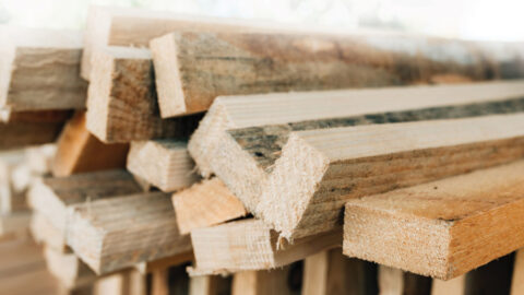 Stacked rustic wooden boards as construction material, selective focus