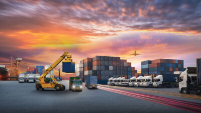 Logistics and transportation of Container Cargo ship and Cargo plane with working crane bridge in shipyard at sunrise, logistic import export and transport industry background